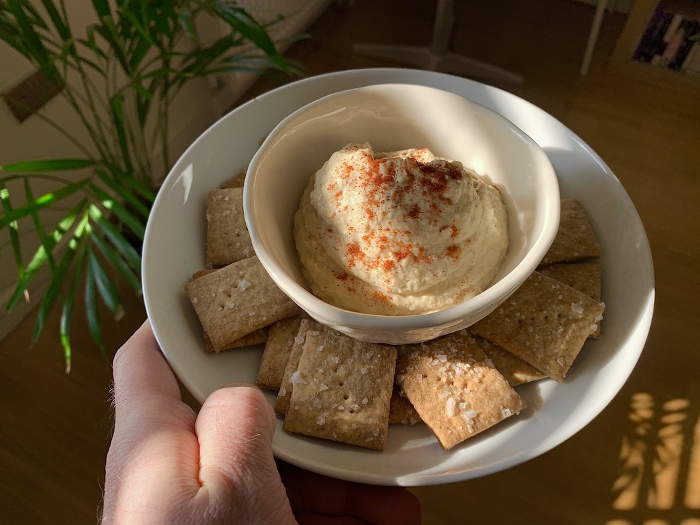 A plate of sourdough crackers and houmous