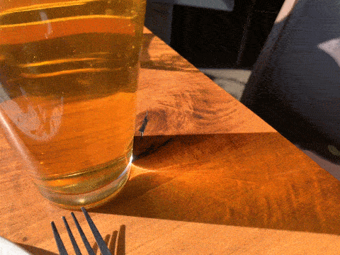 Bubbles rising in a sunlit pint of beer