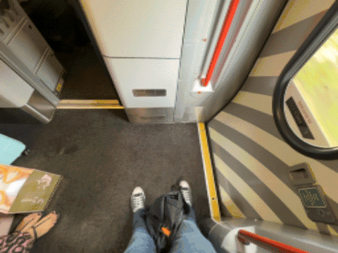 My legs and feet standing in the vestibule of the Sheffield train