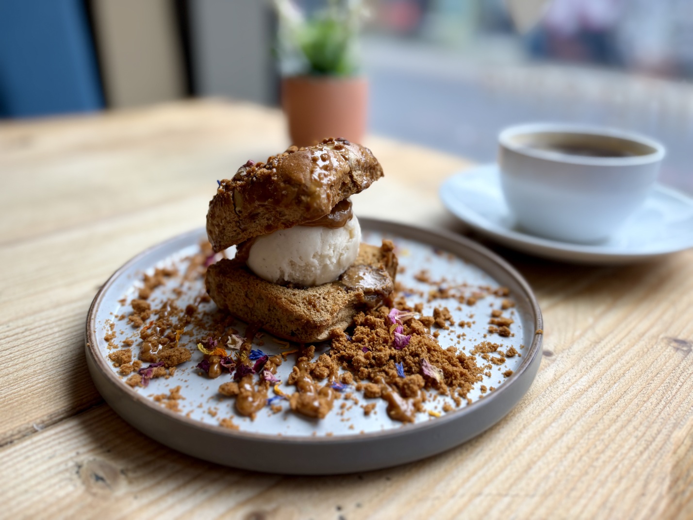 A toasted hot cross bun with ice cream and Biscoff sauce