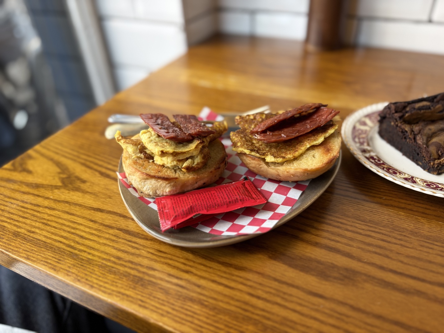 A bagel topped with egg-free omelette and vegan bacon