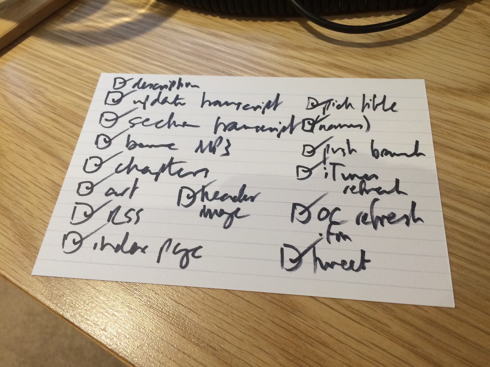 An index card with a long todo list on it: “description”, “update transcript”, “pick title”, “section transcript”, “(names)”, “bounce MP3” etc